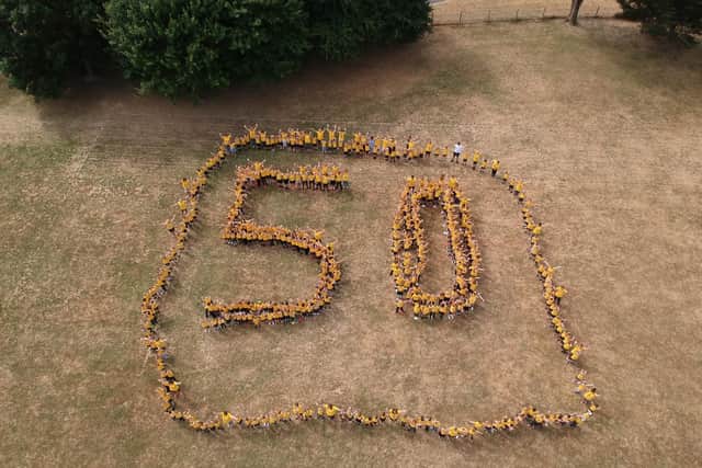 AERIAL VIEW: Staff and pupils at Warren Park spell out 50, dressed in gold. Picture: James Wood
