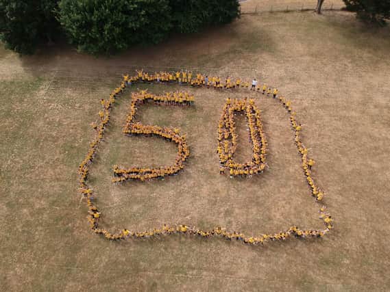 AERIAL VIEW: Staff and pupils at Warren Park spell out 50, dressed in gold. Picture: James Wood