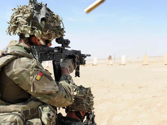 A soldier with A Company, 1 Royal Anglian is pictured firing his rifle