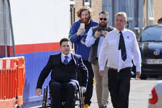 Oliver Redmond, in the wheelchair, followed by a Steamachine employee in purple and Paul Cheape in sunglasses. A security guard showing Redmond the disabled access to Portsmouth Magistrates' Court