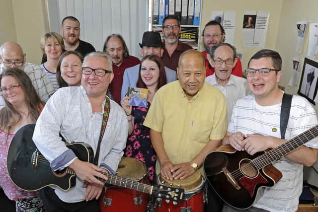 Musical Director Terry Mills (front left) leads the celebrations with staff and clients at Med3 Music in Portsmouth after the charity secured an eleven thousand pounds grant from The Health Lottery