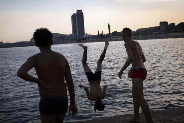 A boy jumps from a dock to the sea during a hot summer day in Barcelona, Spain. Picture: AP Photo/Emilio Morenatti