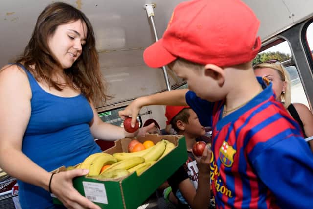 Life Line chairperson Natalie Lunn hands out fresh fruit as a treat for the visiting children