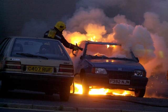 Firefighters tackle a car blaze behind shops in Allaway Avenue, Paulsgrove, which had been set alight while demonstraters gather outside flats where an alleged paedophile was thought to be living.