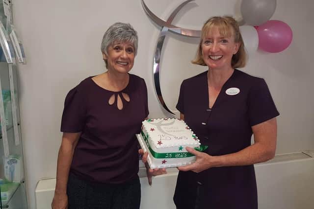 Sharon Nanson, practice manager with Clare Grant, with the cake to commemorate the 25-year anniversary