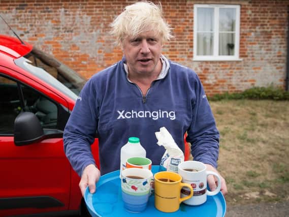 Boris Johnson brings tea for the press to drink outside his house