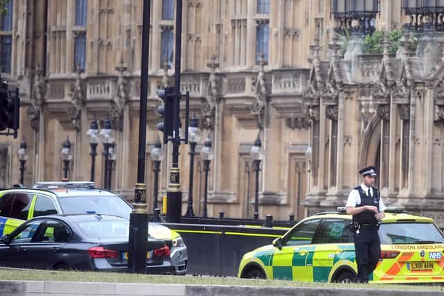 A police officer attends the scene near the Houses of Parliament, Westminster in central London, after a car crashed into security barriers outside the Houses of Parliament. Picture: Victoria Jones/PA Wire