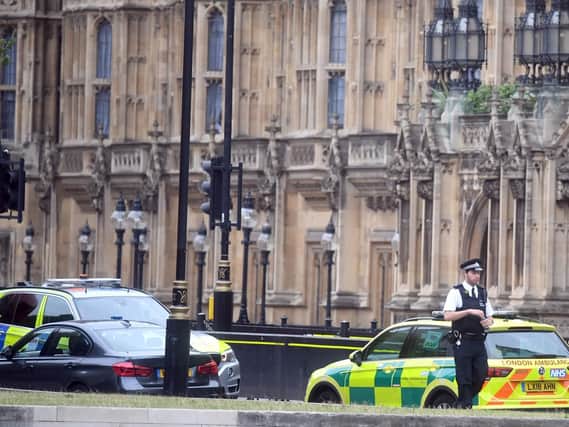 A police officer attends the scene near the Houses of Parliament, Westminster in central London, after a car crashed into security barriers outside the Houses of Parliament. Picture: Victoria Jones/PA Wire