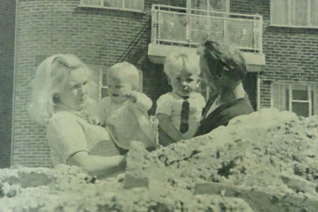 Mr and Mrs Carrick with their children, pictured behind rubble that has accumulated on waste ground outside their flat at Beck Street, Portsea.