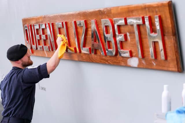 Able Seaman Ryan Whatmore, polishes the name board of HMS Queen Elizabeth, as final preparations are made prior to her setting sail for the US to undergo flight trials with the F35B for the first time Picture: Andrew Matthews/PA Wire