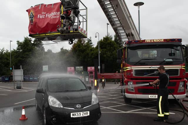 The aerial ladder platform sprays a car. Picture: Vernon Nash (180420-001)