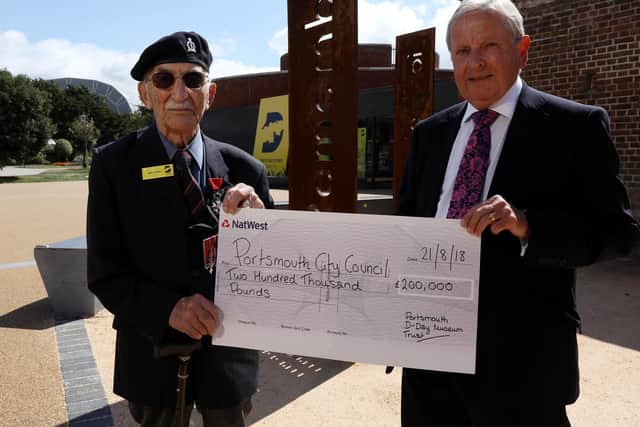 D-Day veteran John Jenkins receives a cheque on behalf of D-Day Story from the chairman of the Portsmouth D-Day Museum Trust, Roger Ching. They are pictured outside the museum in Southsea Picture: Chris Moorhouse