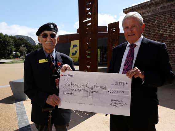D-Day veteran John Jenkins receives a cheque on behalf of D-Day Story from the chairman of the Portsmouth D-Day Museum Trust, Roger Ching. They are pictured outside the museum in Southsea Picture: Chris Moorhouse