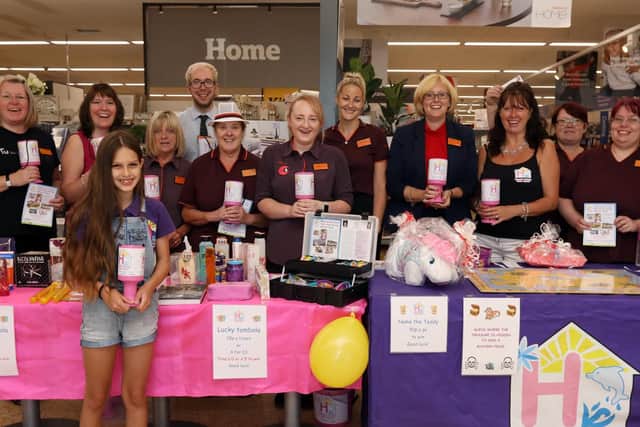 Sainsburys colleagues including operations manager Lizzie Spacey, fourth right, welcome Pam Marshall, third right, and her daughter, Grace, 11, front. Hannahs Holiday Home Appeal has been chosen as Charity Of The Year at Sainsburys Farlington Picture: Chris Moorhouse