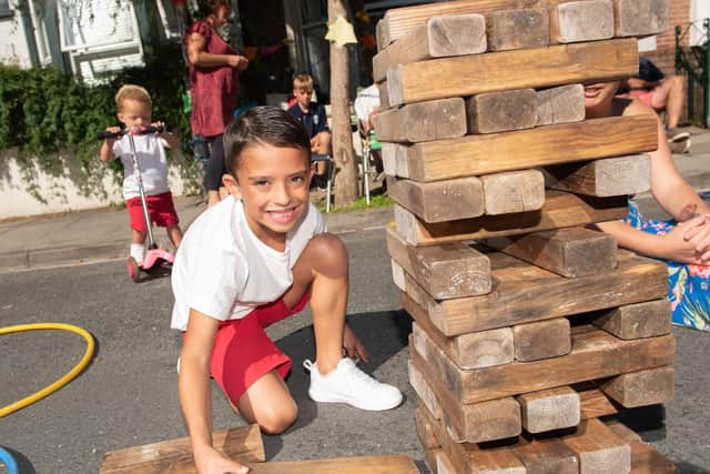 FUN DAY: Street Party in Allens Road, Southsea - Riley Bridgman, nine, plays a giant game of Jenga with Che Molyneaux on a scooter behind. Picture: Vernon Nash (180429-014)