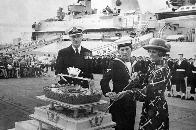 Captain Beeson, James Craw and Mrs Beeson cut the commissioning cake.