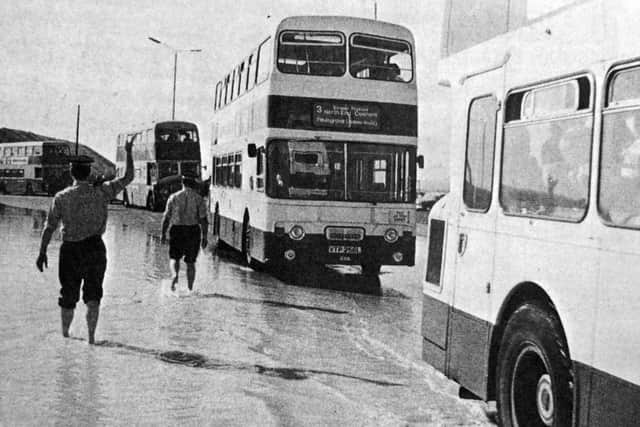 Hampshire police, with their shoes and socks off, direct traffic away from the floods.