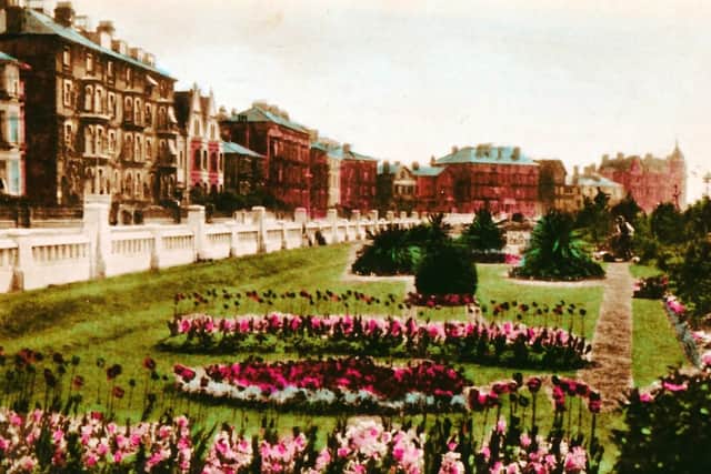 Looking east, with Clarence Parade on the left,  two gardeners work on the immaculate gardens on Southsea seafront.