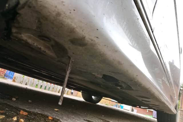 The piece of metal lodged in the bodywork Dan Chapman's BMW 320 - with damage it did to the skirting