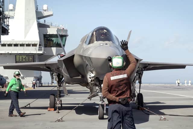 Royal Navy Commander, Nathan Gray, 41, made history by being the first to land on, carefully manoeuvring his stealth jet onto the thermal coated deck. He is pictured in his jet. Photo: Royal Navy