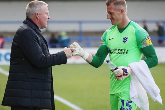 Pompey boss Kenny Jackett, left, toasts his side's win at Rochdale with keeper Craig MacGillivray. Picture: Joe Pepler