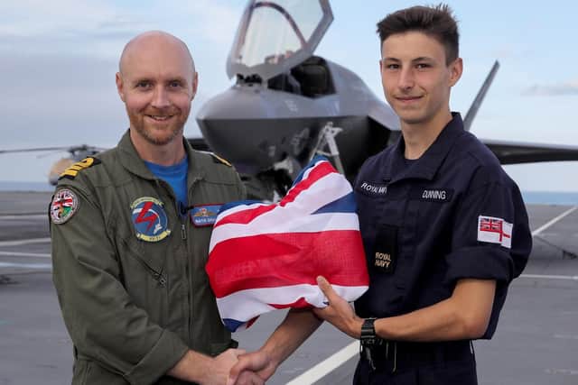 Commander Nathan Grey RN presents the Ensign to AB (AWW) Aaron Dunning. Photo: Royal Navy