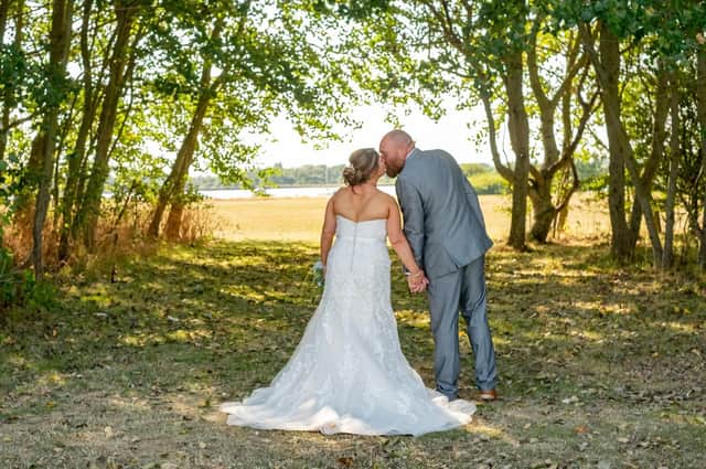 Tina and Kev share a kiss under the sun on their wedding day. Picture: Carla Mortimer Photography