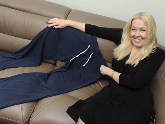Kerrie Bailey with a pair of trousers she wore before her dramatic weight loss