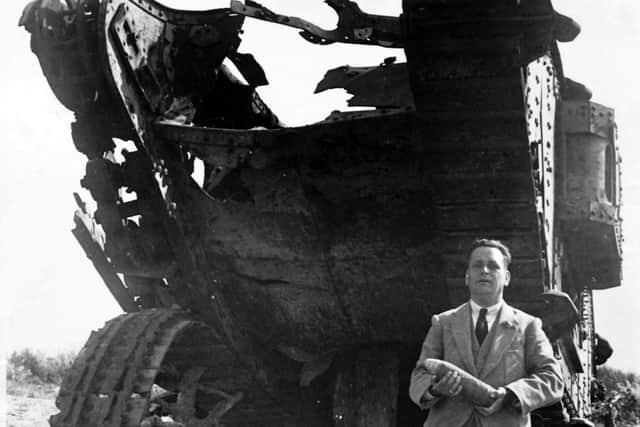 Councillor Charles Brown posing in front of a wrecked tank and holding a live shell. Picture: Tony Davis Collection.