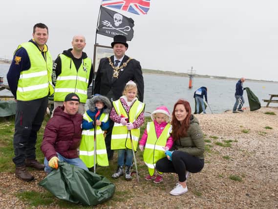 Cleaning up at the Eastney beach clean - standing, from left: Peter May of The Princess of Wales Royal Regiment; Sea Shepherd Phil Carpenter and The Lord Mayor of Portsmouth, cllr Lee Mason. Front, from left: the Davies family, Michael, Tristan (5yrs), Sommer (6yrs), Penelope (3yrs) and Emma     Picture: Duncan Shepherd