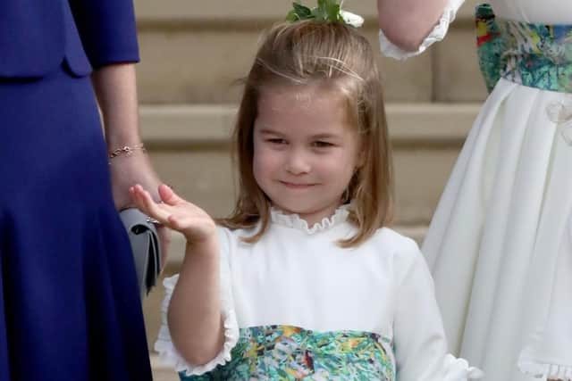 Princess Charlotte waves to Princess Eugenie and her new husband Jack Brooksbank as they leave St George's Chapel in Windsor Castle following their wedding. Picture: Andrew Matthews/PA Wire