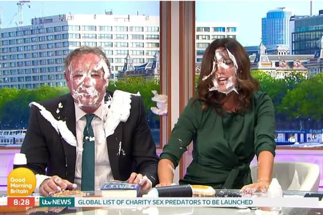 A screengrab from ITV's Good Morning Britain after Piers Morgan, left, sat next to fellow presenter Susanna Reid, was hit in the face by a pie from comedian Harry Hill. Picture: ITV / PA Wire