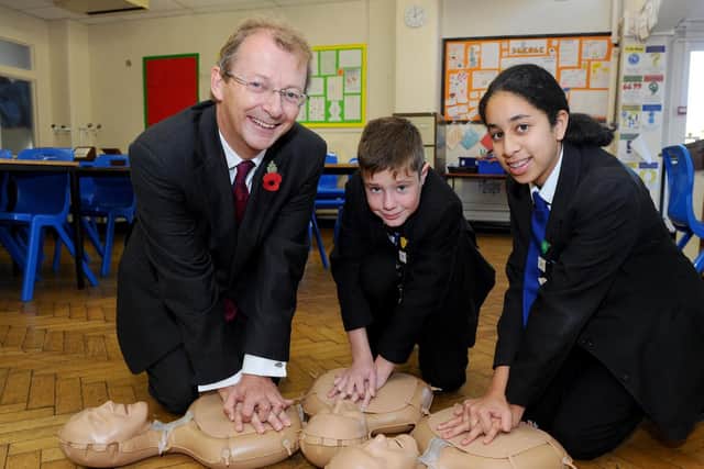 Year 8 pupils from Mayfield School, in Portsmouth, took part in a Restart a Heart Day. Pictured is Professor Charles Deakin, medical director for South Central Ambulance Service, James Hudson-Hall, 12, and Karima Al-Sharrai, 12. Picture: Sarah Standing (180778-6712)