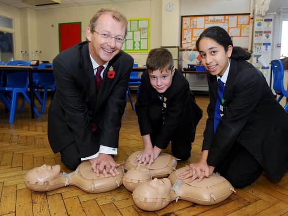 Year 8 pupils from Mayfield School, in Portsmouth, took part in a Restart a Heart Day. Pictured is Professor Charles Deakin, medical director for South Central Ambulance Service, James Hudson-Hall, 12, and Karima Al-Sharrai, 12. Picture: Sarah Standing (180778-6712)