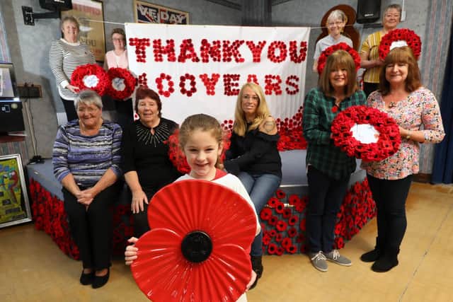 Ladies from the Royal British Legion club have knitted and crochetted poppies for their club and to dress Portsmouth Guildhall for Armistice Day. Hollie Tipler, 6, front Picture: Chris Moorhouse