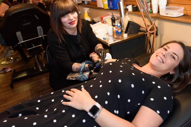 Emily Handley is tatooed by Paige Ord. Emily has also completed the Brighton Marathon this year and is entered for the London Marathon in April 2019, both in aid of the Alzheimer's Society. Picture: Duncan Shepherd