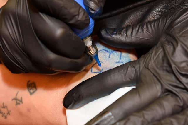 The forget-me-not flower being tattooed. Picture: Duncan Shepherd