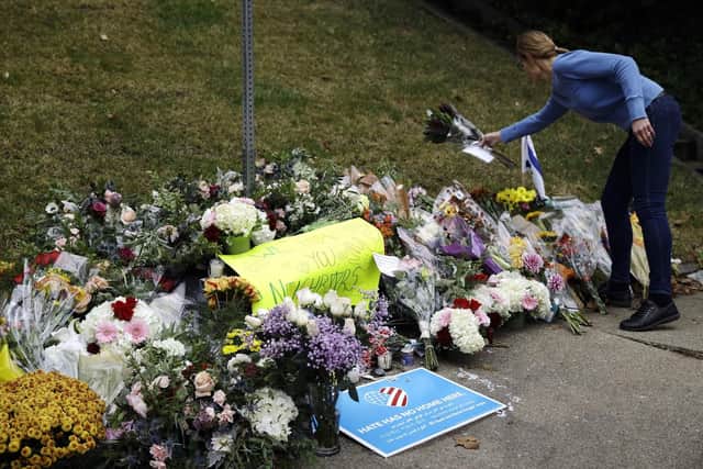 A person brings flowers to a makeshift memorial at the Tree of Life Synagogue in Pittsburgh. Picture: AP Photo/Matt Rourke
