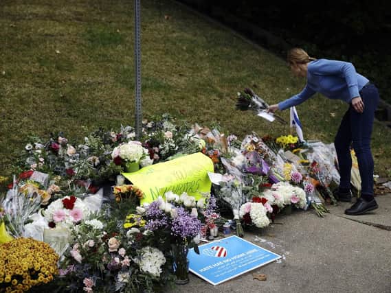 A person brings flowers to a makeshift memorial at the Tree of Life Synagogue in Pittsburgh. Picture: AP Photo/Matt Rourke