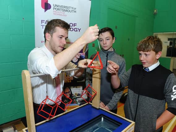 Left to right, Jake Harrold, a trainee teacher in computing doing a PGCE in the education and sociology department, who was helping the Faculty of Technology to promote STEM, with Harrison Davies, 13, and Joseph Mooney, 13. Picture: Sarah Standing (180806-7793)