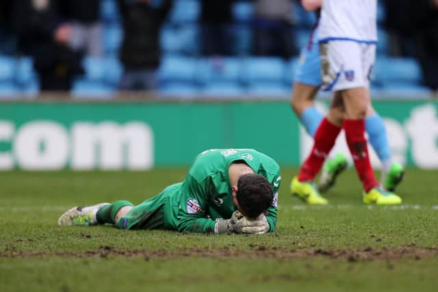 A dejected Trevor Carson after Pompey concede their fifth goal in a familiar Glanford Park defeat in February 2014. Picture: Joe Pepler