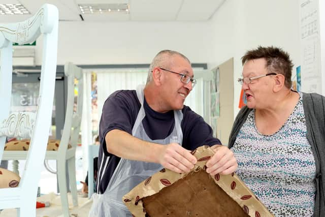 Vince Wymss and Yvonne Fornalski discuss details of re-upholstering a cushion