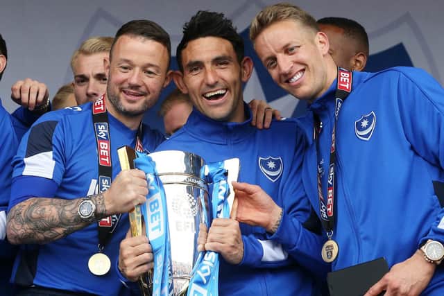 Gary Roberts, centre, celebrates with the League Two title alongside Noel Hunt, left, and Carl Baker. Picture: Joe Pepler