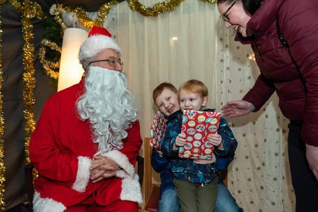 Christmas Fair at Portsmouth Cathedral - Logan, eight, and Sebastian Dewey, three, meet and get presents from Santa with their mum Natasha  Picture: Vernon Nash (180688-006)