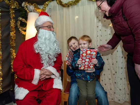 Christmas Fair at Portsmouth Cathedral - Logan, eight, and Sebastian Dewey, three, meet and get presents from Santa with their mum Natasha  Picture: Vernon Nash (180688-006)