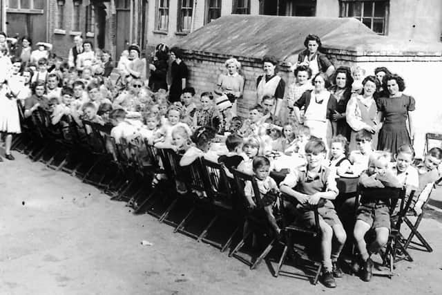 VE-Day street party. Does anyone recognise the street? In the background is a brick-built air raid shelter.
