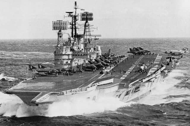 HMS Ark Royal powering through a lively sea in 1977 with a flight of Phantom, Buccaneer and Gannet aircraft on her deck.