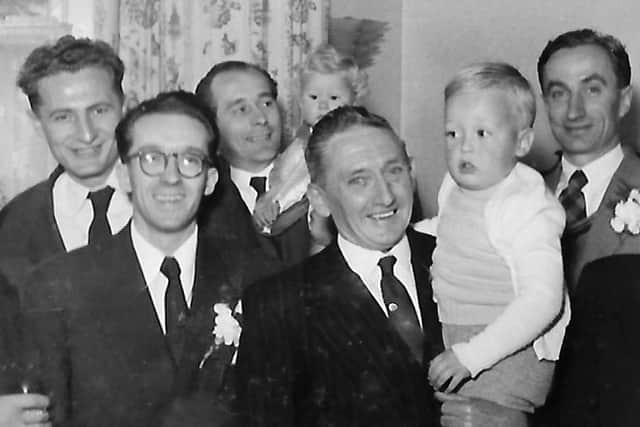 Henry with fellow countrymen. He is third from the left (at the back) holding his baby son Stephen.