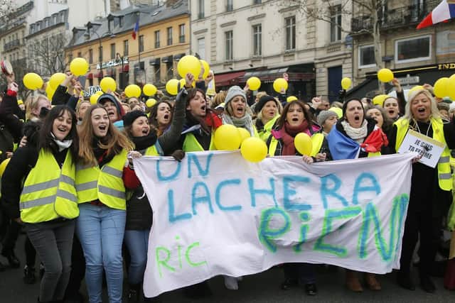 Women wearing yellow vests and holding yellow balloons march during a protest in Paris, Sunday, Jan. 6, 2019. Several hundred women wearing yellow vests march during a rally in Paris to give a different image to the movement. (AP Photo//Michel Euler)