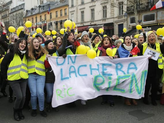 Women wearing yellow vests and holding yellow balloons march during a protest in Paris, Sunday, Jan. 6, 2019. Several hundred women wearing yellow vests march during a rally in Paris to give a different image to the movement. (AP Photo//Michel Euler)